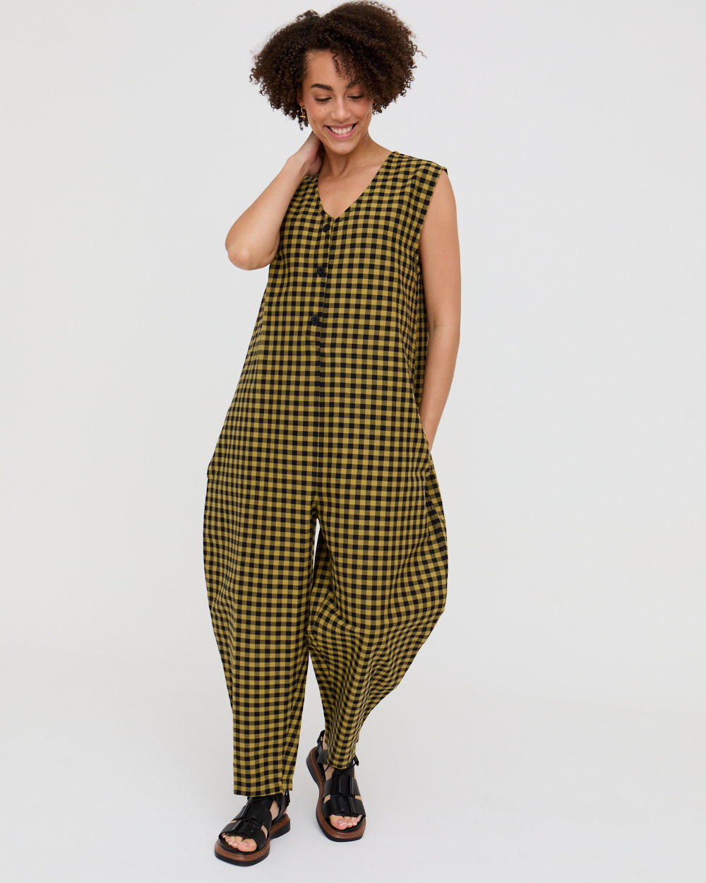 Woman wearing a green and black checkered jumpsuit on a white background