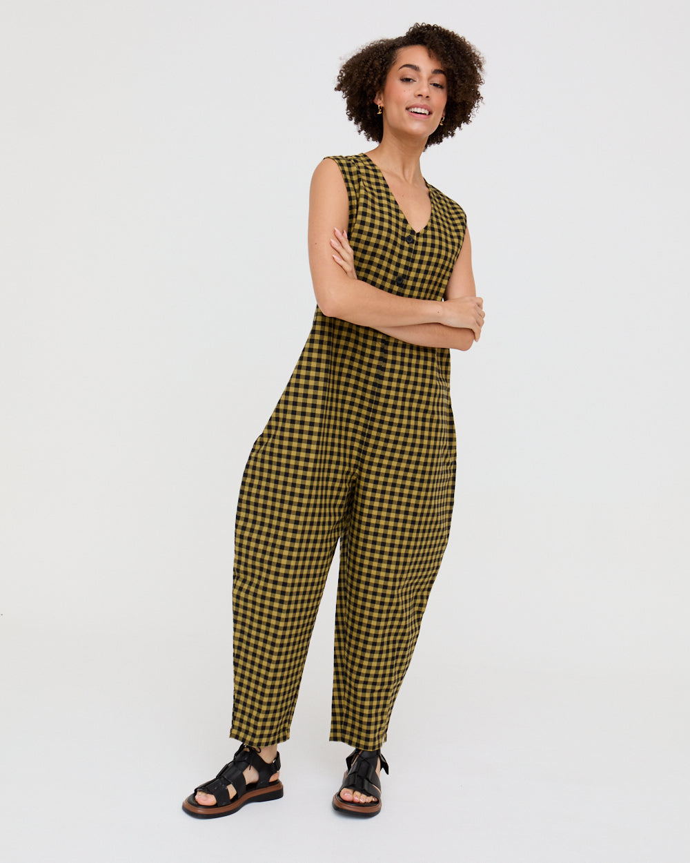 Woman wearing a green and black checkered jumpsuit on a white background