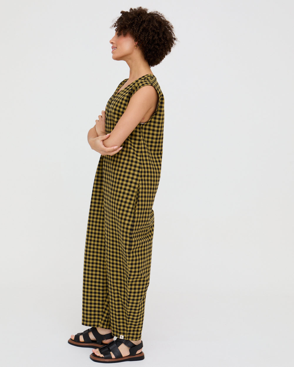 Woman wearing a yellow and black checkered dress on a white background