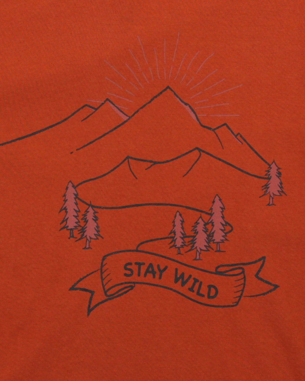 The Wild Mountains Top features an illustration of mountains and pine trees on an orange backdrop, with a river winding through. STAY WILD is displayed on a ribbon below, while sun rays highlight the peaks, embodying natures spirit in this eco-friendly kids top.