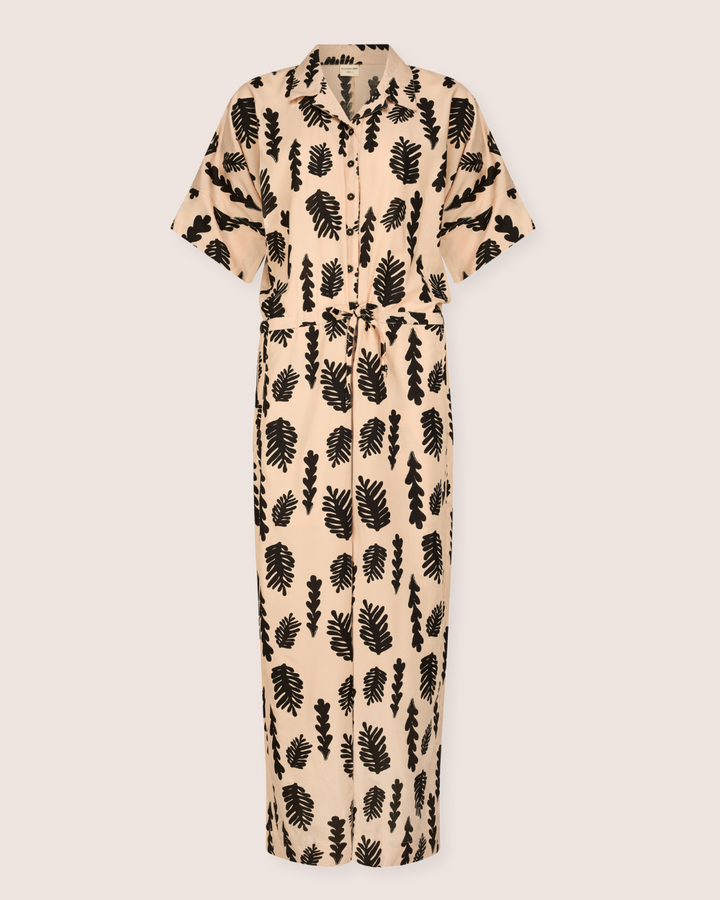 The Iris Seaweed Print Jumpsuit features a black leaf pattern on beige EcoVero viscose. It has short sleeves, a collar, and a long, straight silhouette.