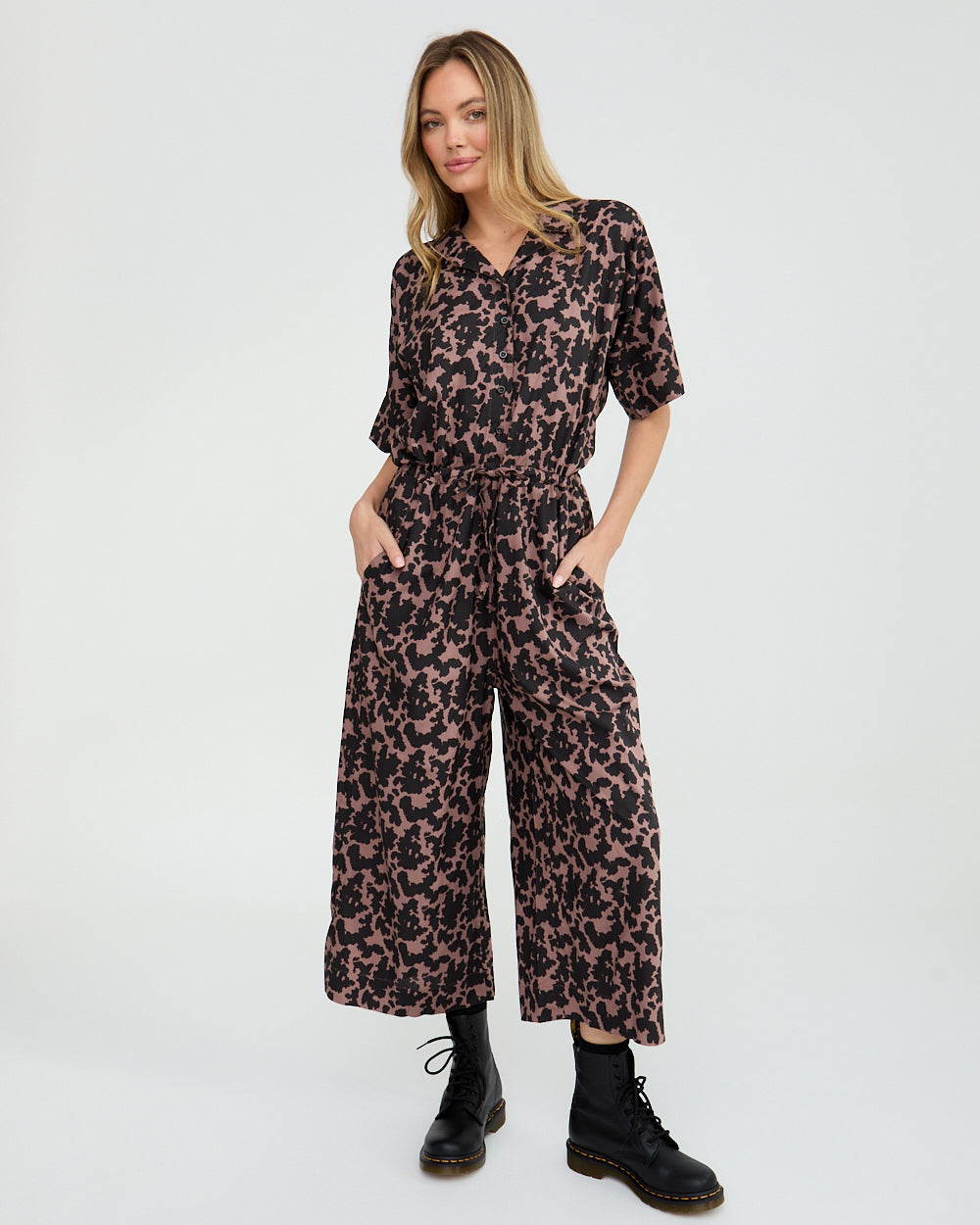 Woman wearing a leopard print jumpsuit on a white background
