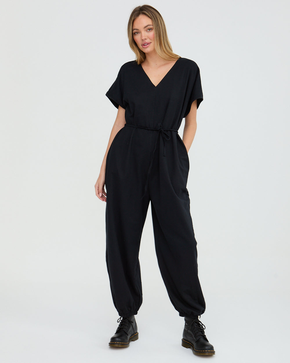 Woman wearing a black jumpsuit on a white background