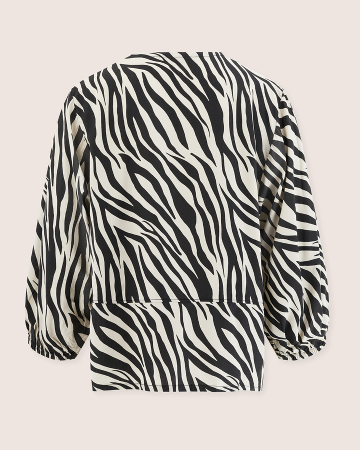 Back view of the Blake Zebra Print Tie Blouse Top, showcasing a striking black and white zebra pattern on a light pink background. Crafted from Eco Viscose, it features elastic cuffs and a loose fit for effortless elegance.