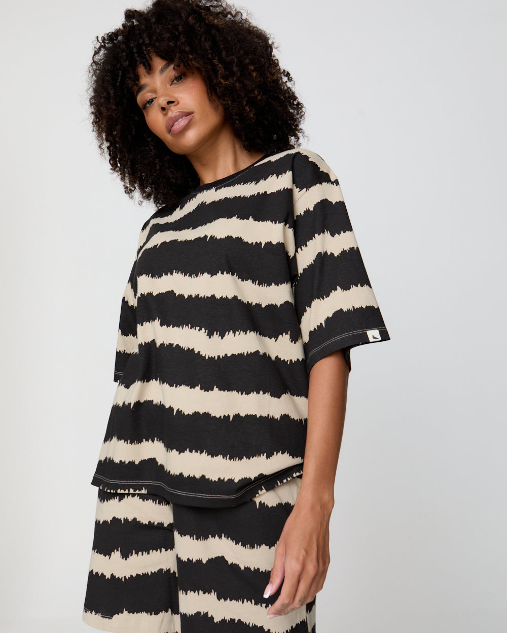 Woman wearing a black and white striped shirt against a plain background