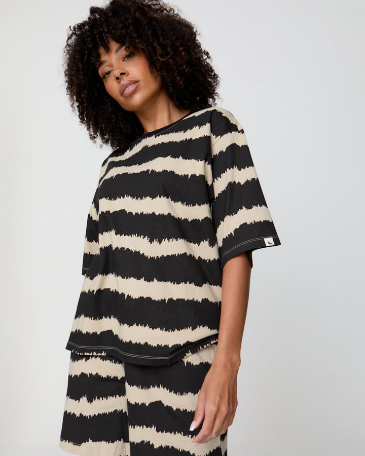 Woman wearing a black and white striped shirt against a plain background