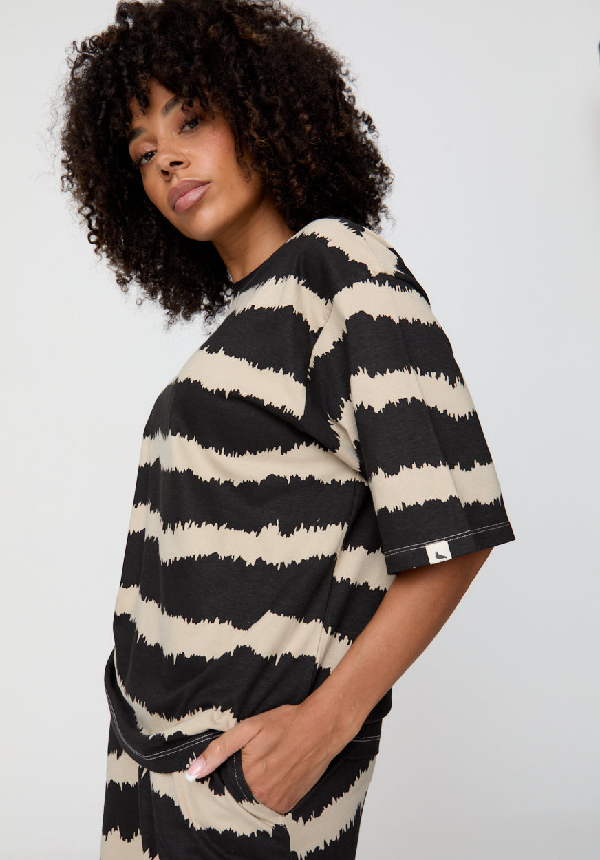 Woman wearing a black and white striped dress against a plain background