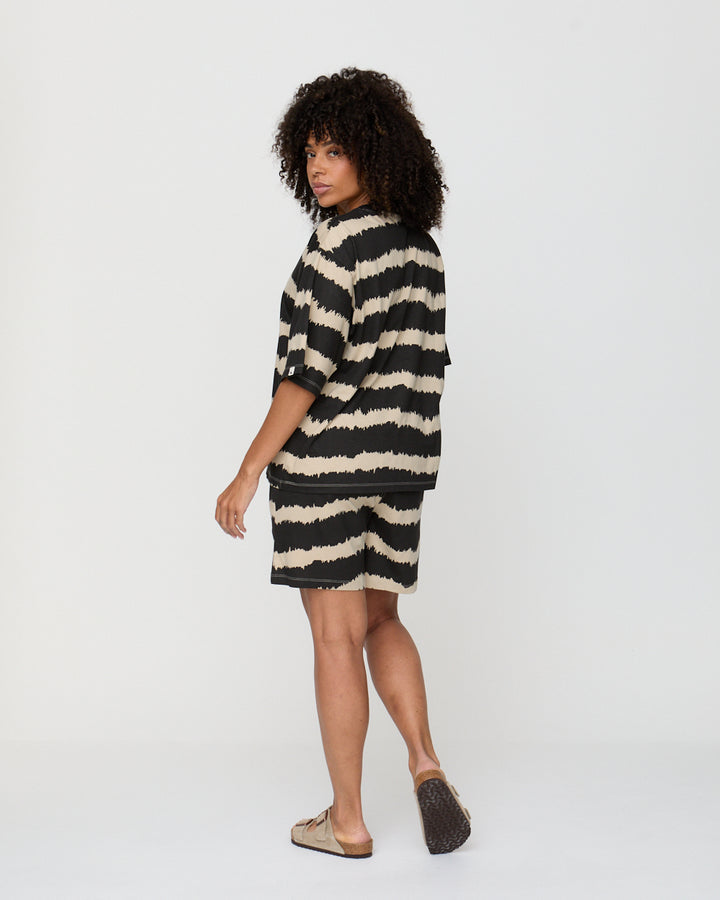 Woman wearing a black and white striped dress on a white background