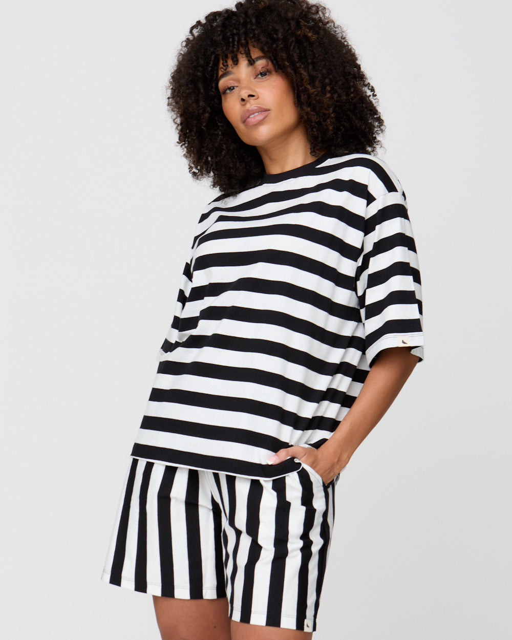Woman wearing a black and white striped outfit on a plain background