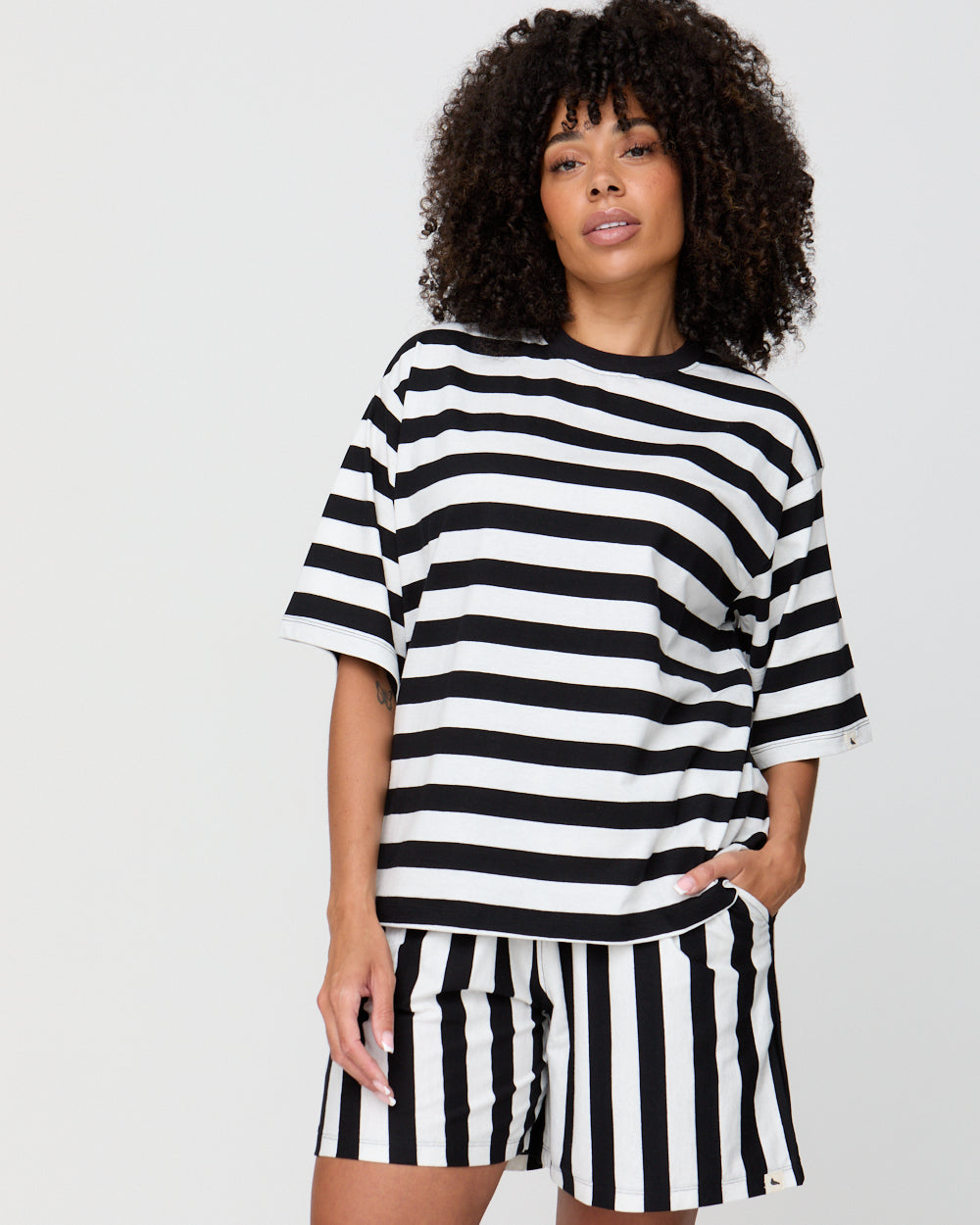 Person wearing a black and white striped outfit on a plain background