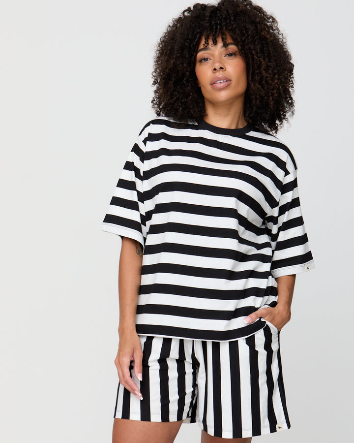 Person wearing a black and white striped outfit on a plain background