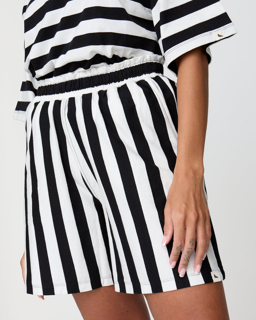 Black and white striped outfit with a top and shorts on a plain background