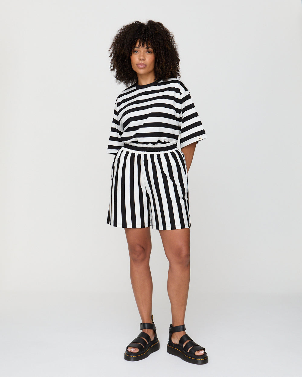Person wearing a black and white striped outfit on a plain background