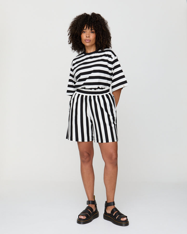Person wearing a black and white striped outfit on a plain background