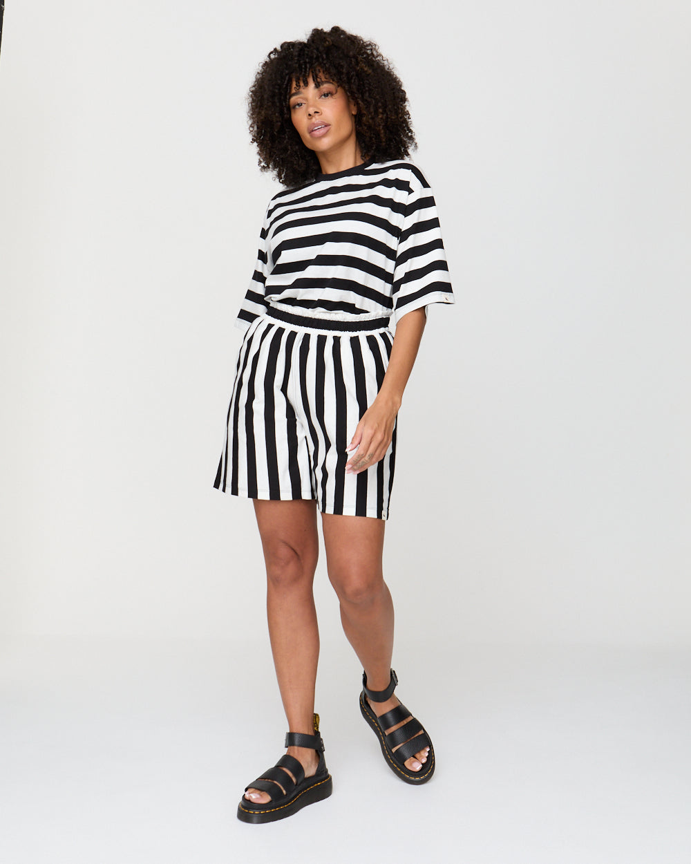 Woman wearing a black and white striped outfit on a white background