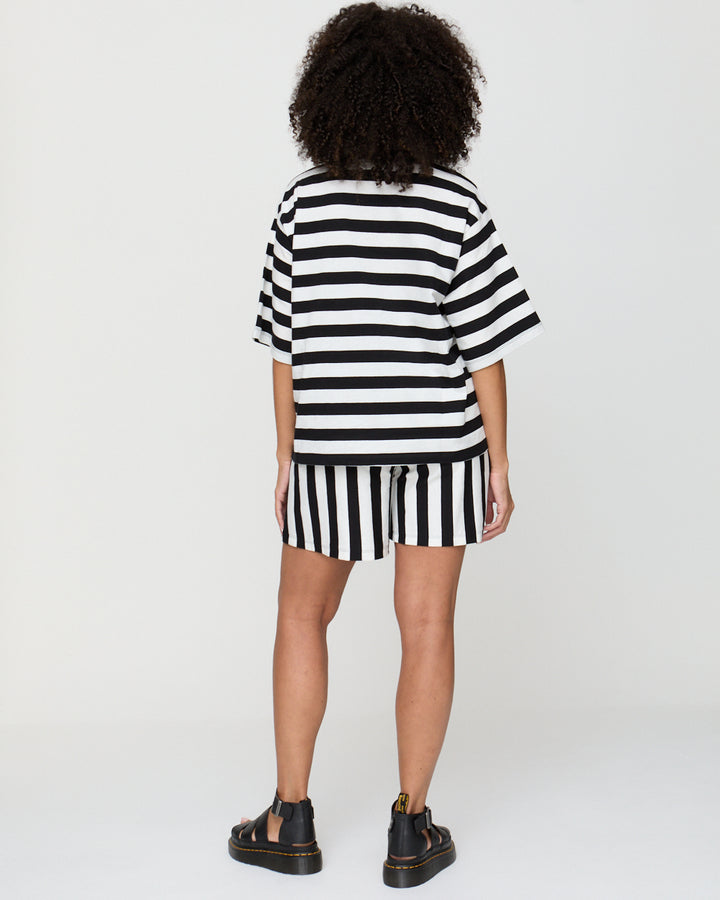 Person wearing a black and white striped dress on a plain background