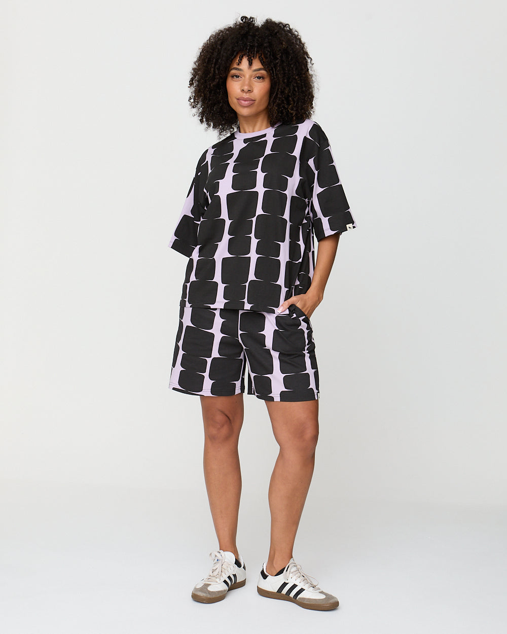 Person wearing a black and white patterned outfit on a plain background