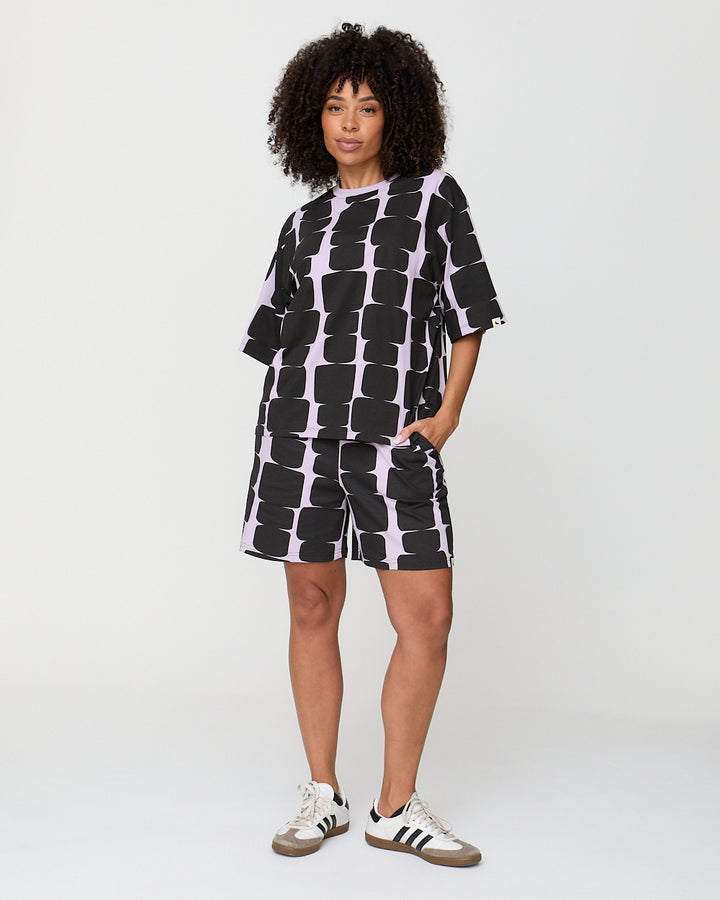 Person wearing a black and white patterned outfit on a plain background