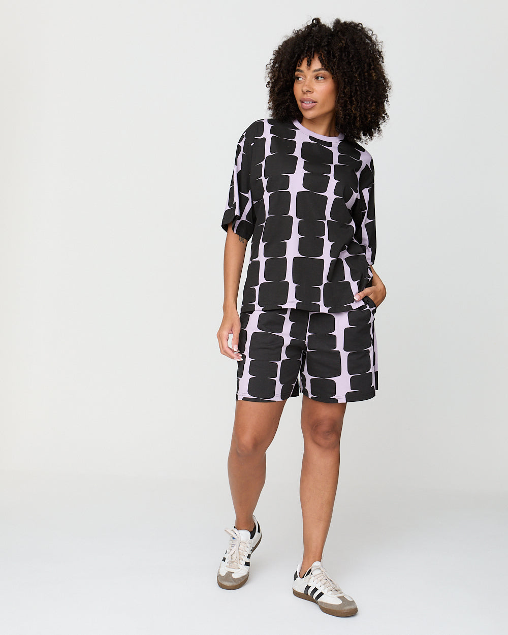 Woman wearing a black and white patterned outfit on a white background
