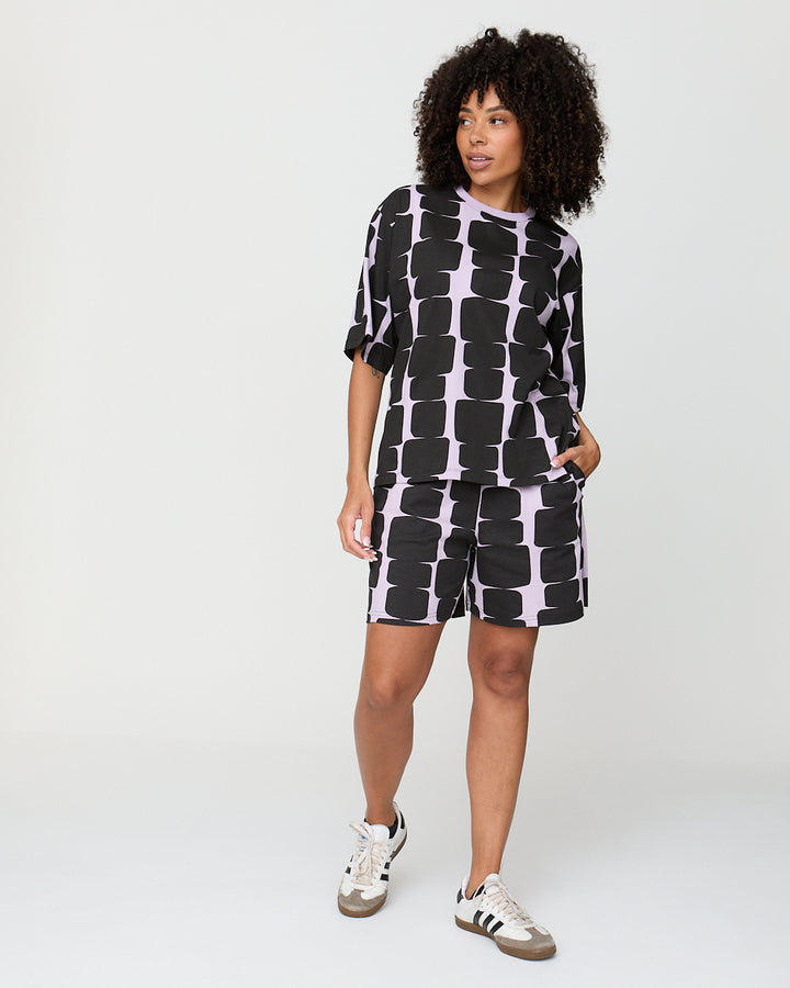 Woman wearing a black and white patterned outfit on a white background
