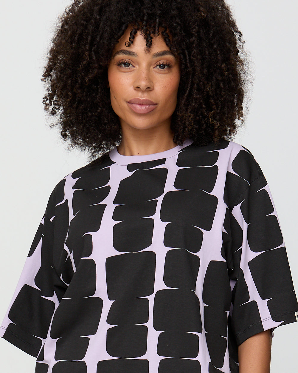 Woman wearing a black and white patterned dress against a plain background