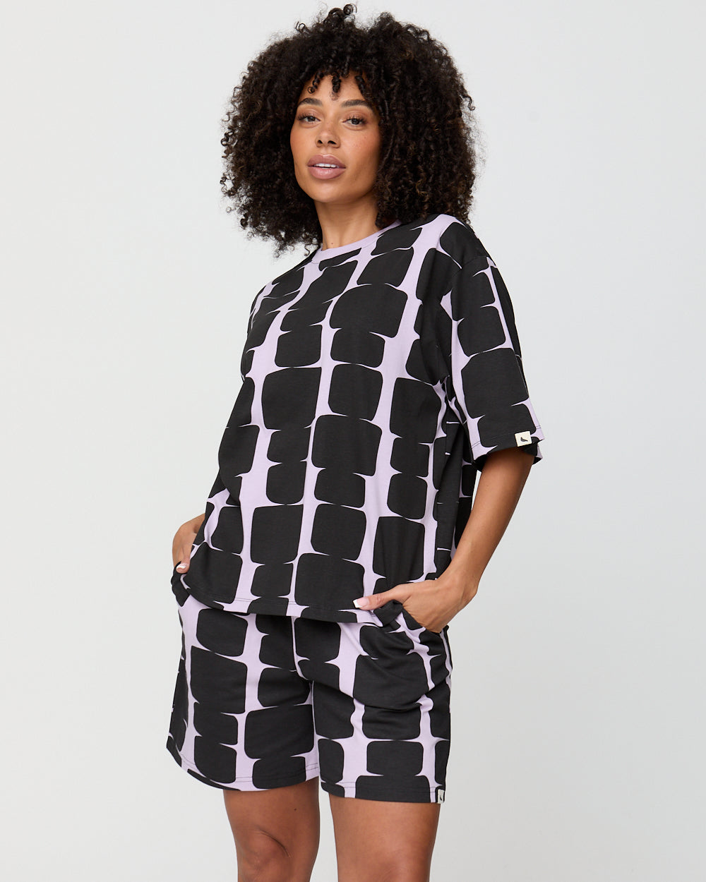 Woman wearing a black and white patterned outfit on a plain background