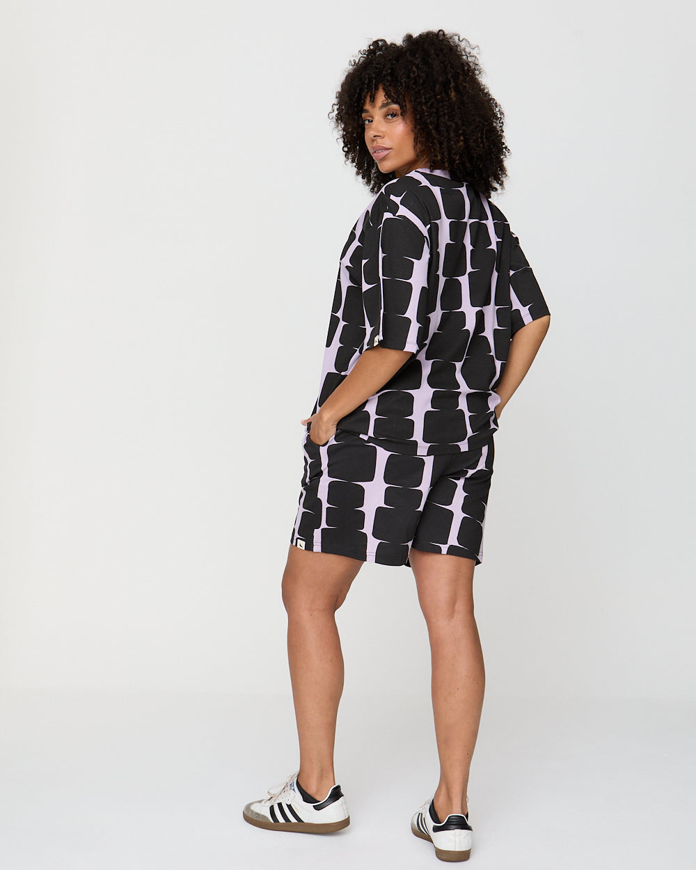 Woman wearing a black and white patterned dress on a white background