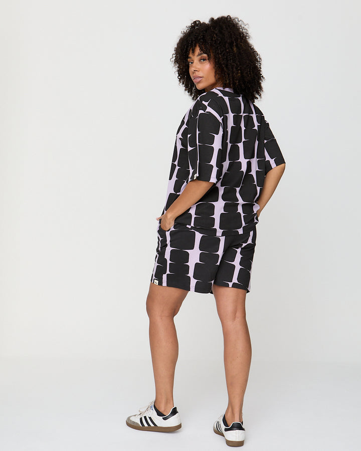 Woman wearing a black and white patterned dress on a white background