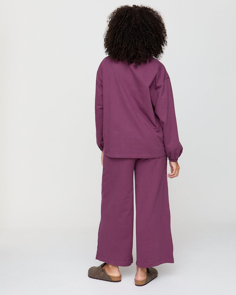 Person wearing a purple outfit on a white background