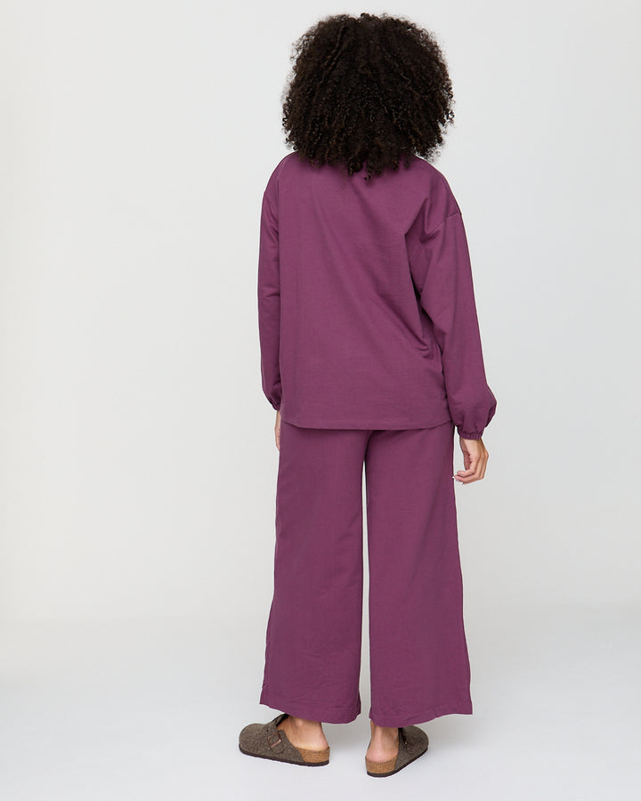 Person wearing a purple outfit on a white background