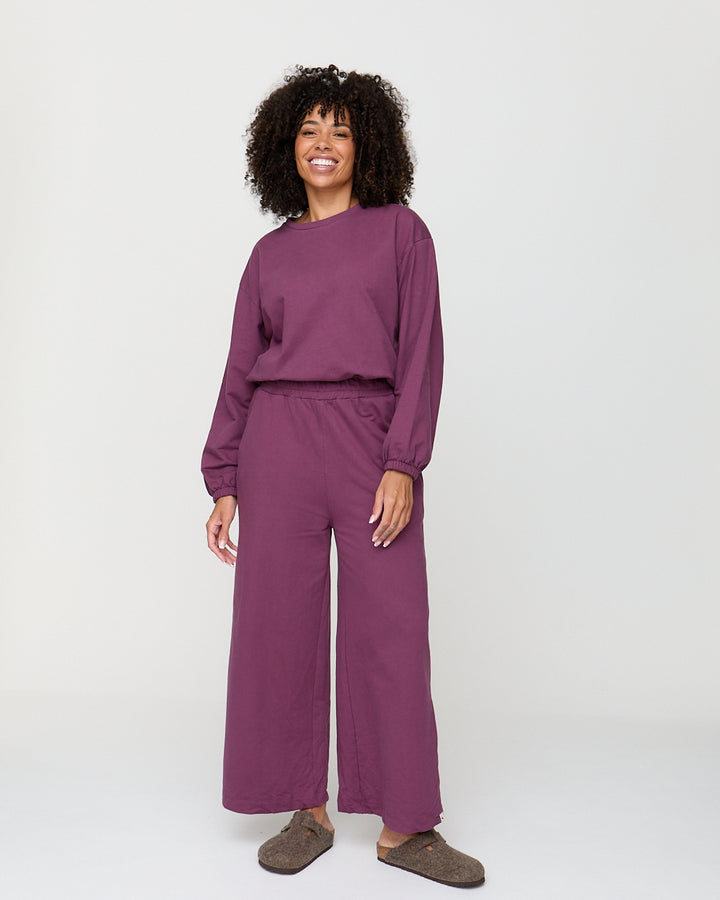 Person wearing a purple outfit on a white background