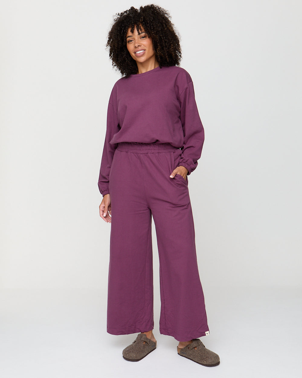 Woman wearing a purple outfit on a white background