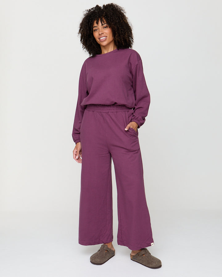Woman wearing a purple outfit on a white background