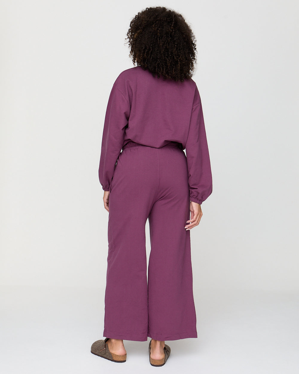 Person wearing a purple outfit on a white background