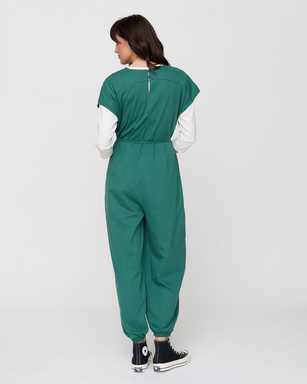 Person wearing a green jumpsuit on a white background
