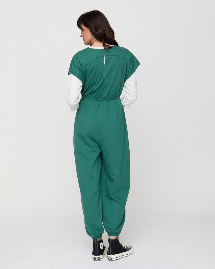 Person wearing a green jumpsuit on a white background