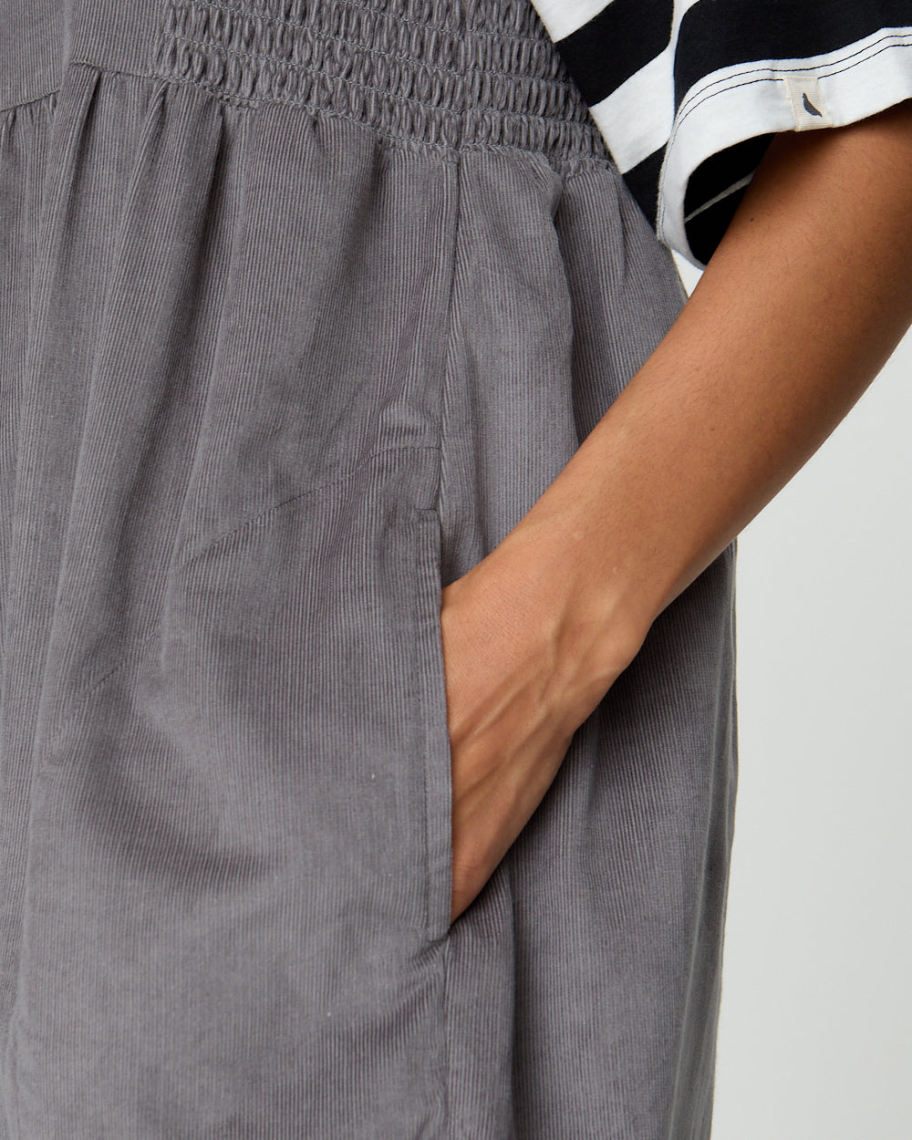 Gray pants with a person wearing them on a plain background