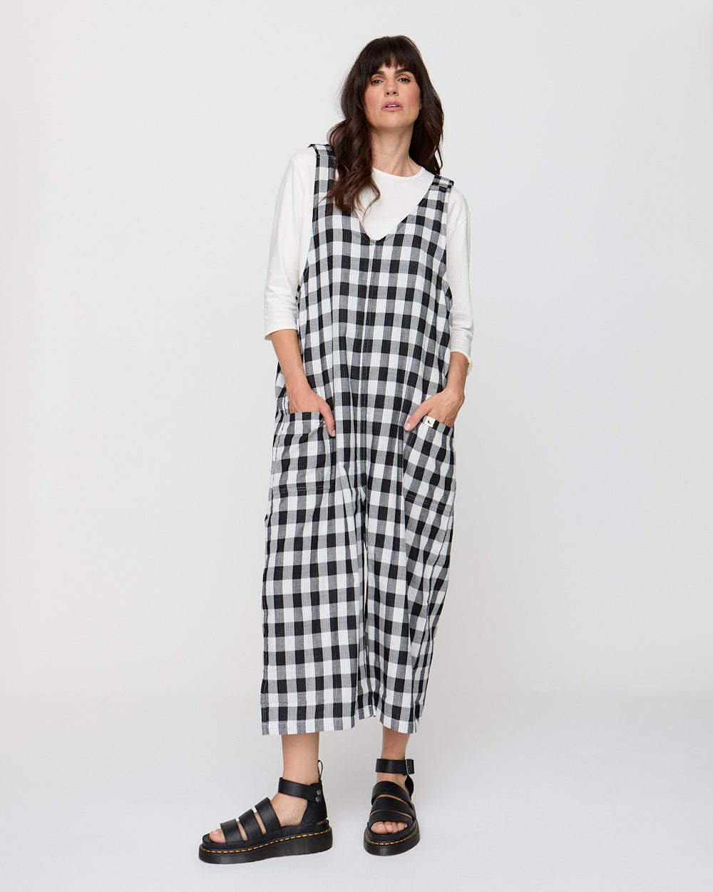 Woman wearing a black and white checkered dress against a white background