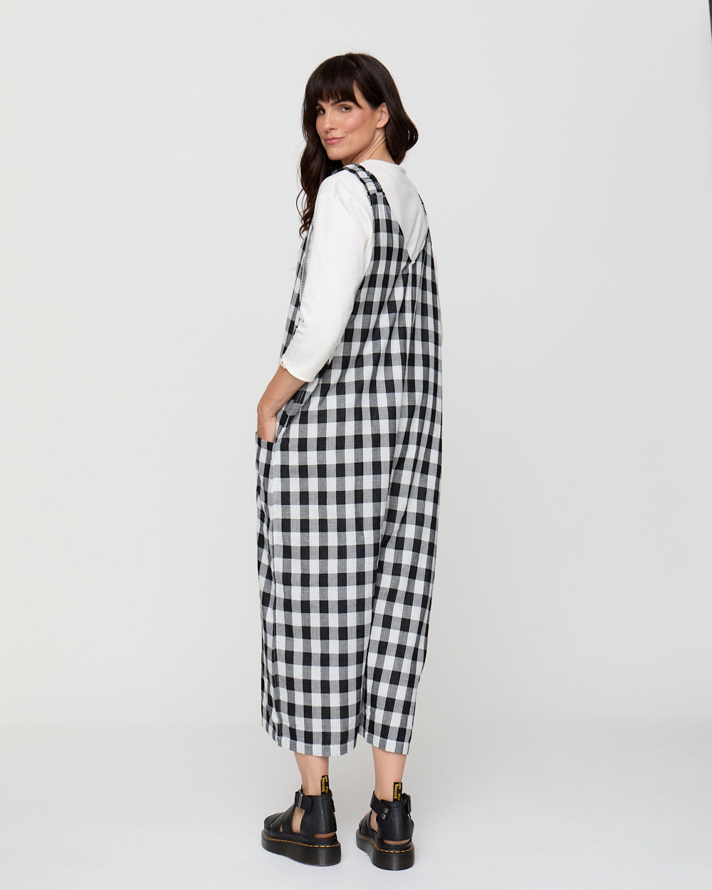 Woman wearing a black and white checkered dress against a white background