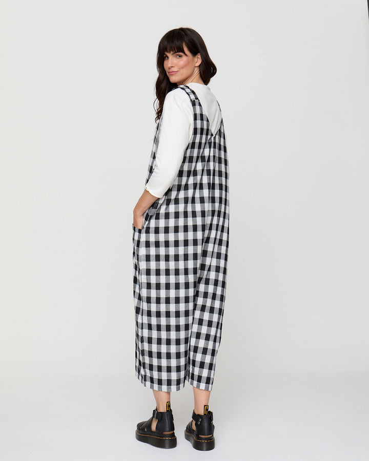 Woman wearing a black and white checkered dress against a white background