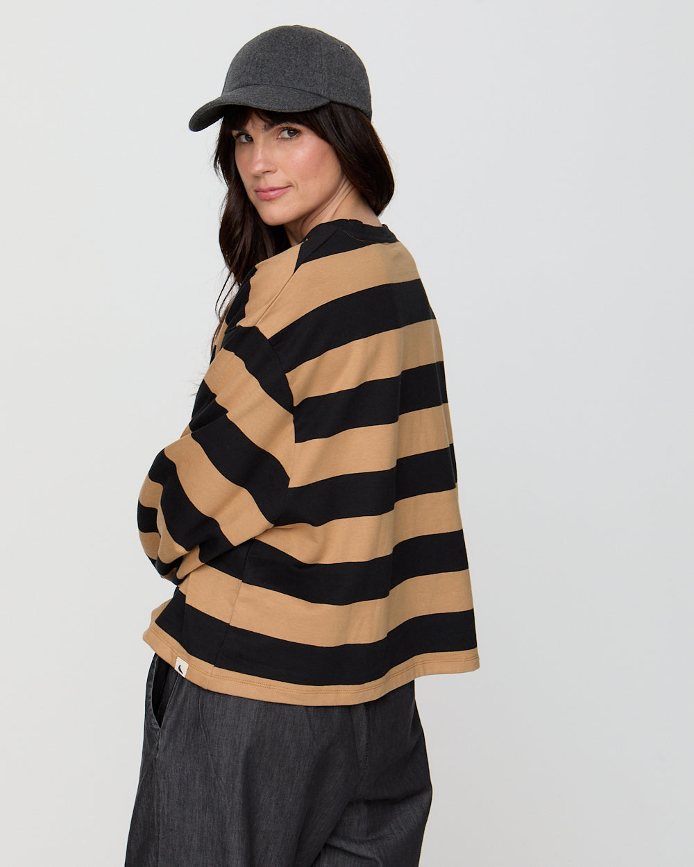 Person wearing a striped sweater and cap on a plain background