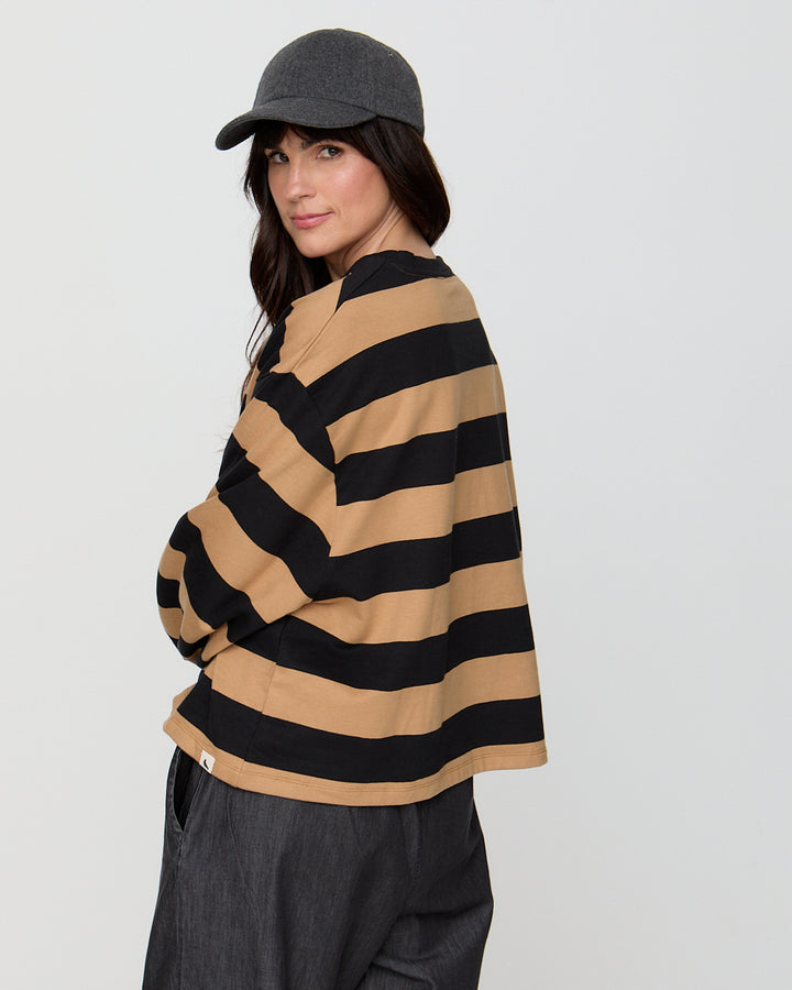 Person wearing a striped sweater and cap on a plain background