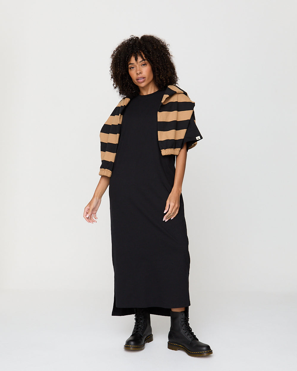 Woman wearing a black dress with a striped shawl on a white background