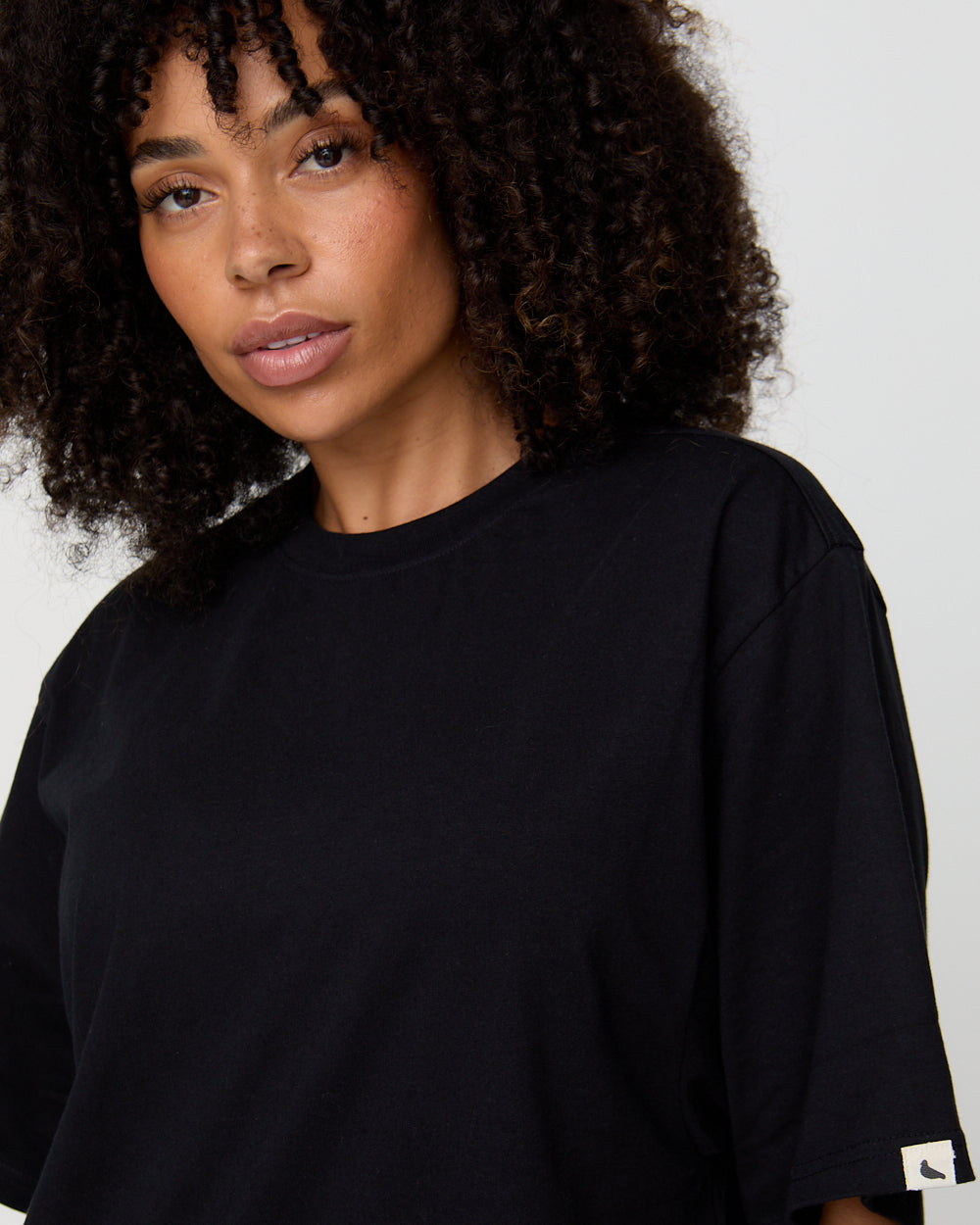 Woman wearing a black t-shirt against a plain background