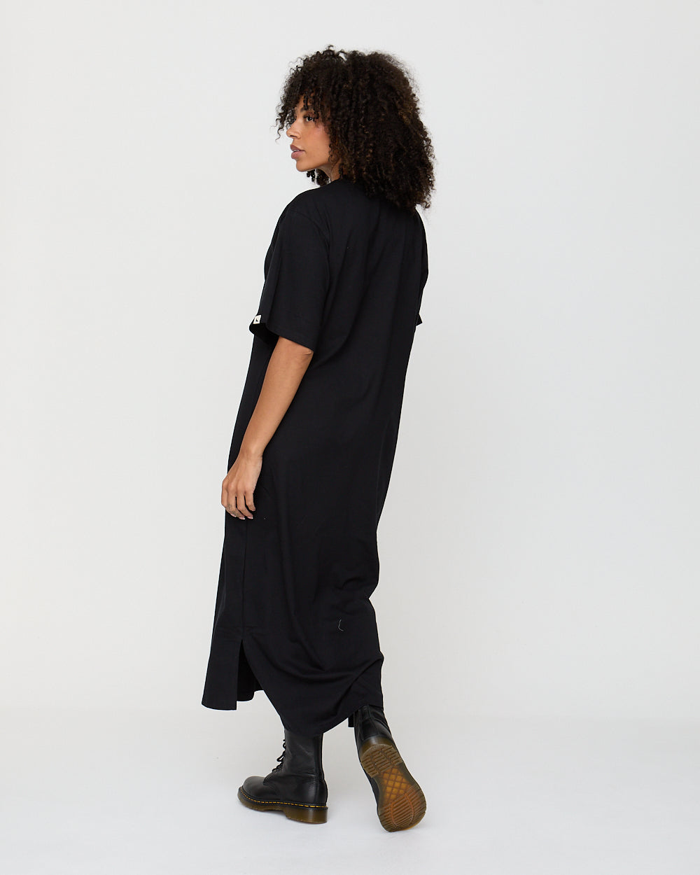 Person wearing a black dress with a white background