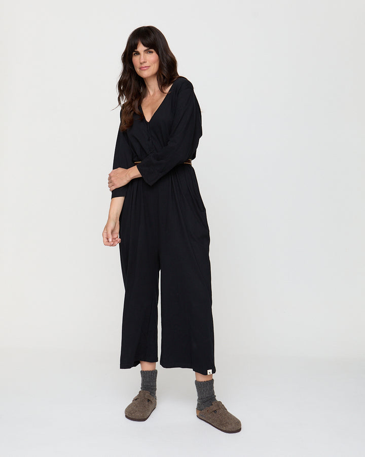 Woman wearing a black jumpsuit on a white background
