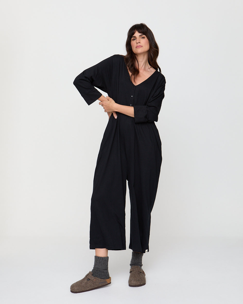 Woman wearing a black jumpsuit on a white background