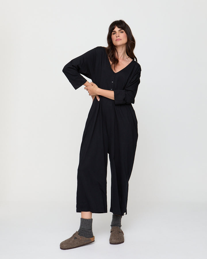 Woman wearing a black jumpsuit on a white background