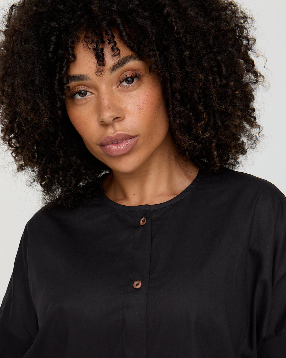 Woman wearing a black shirt with a plain background