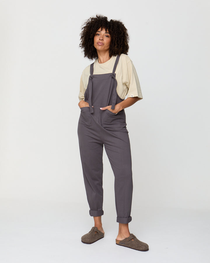 Person wearing gray overalls on a white background